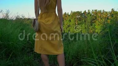 <strong>日</strong>落时分，一位穿着黄色衣服的年轻女子在坎布汉岭散步或画家`的<strong>超级</strong>慢镜头